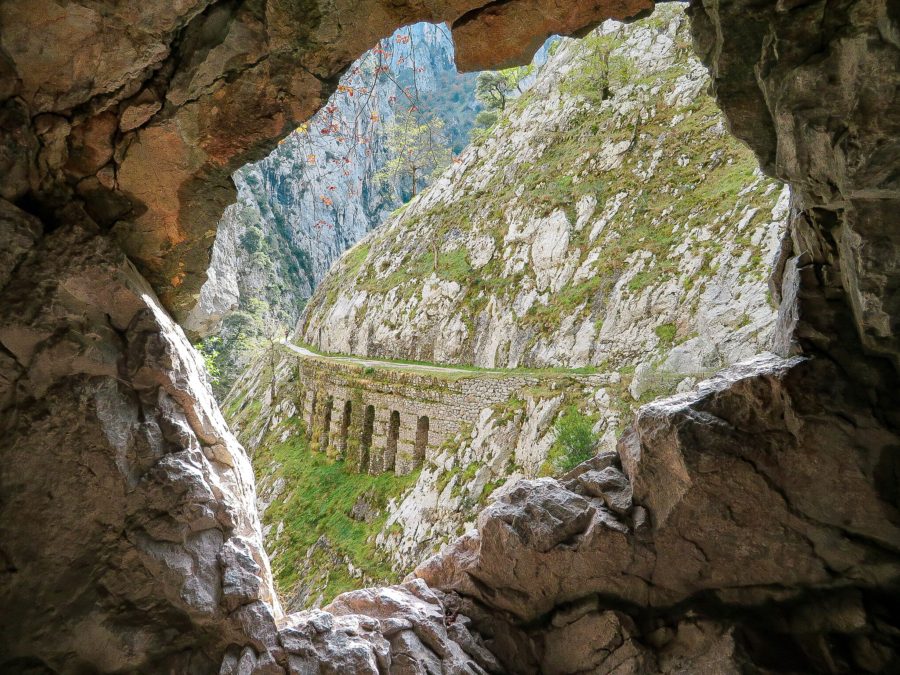 one of the best views on the Cares Gorge hike in the Picos de Europa National Park of a stone bridge and karst limestone mountains