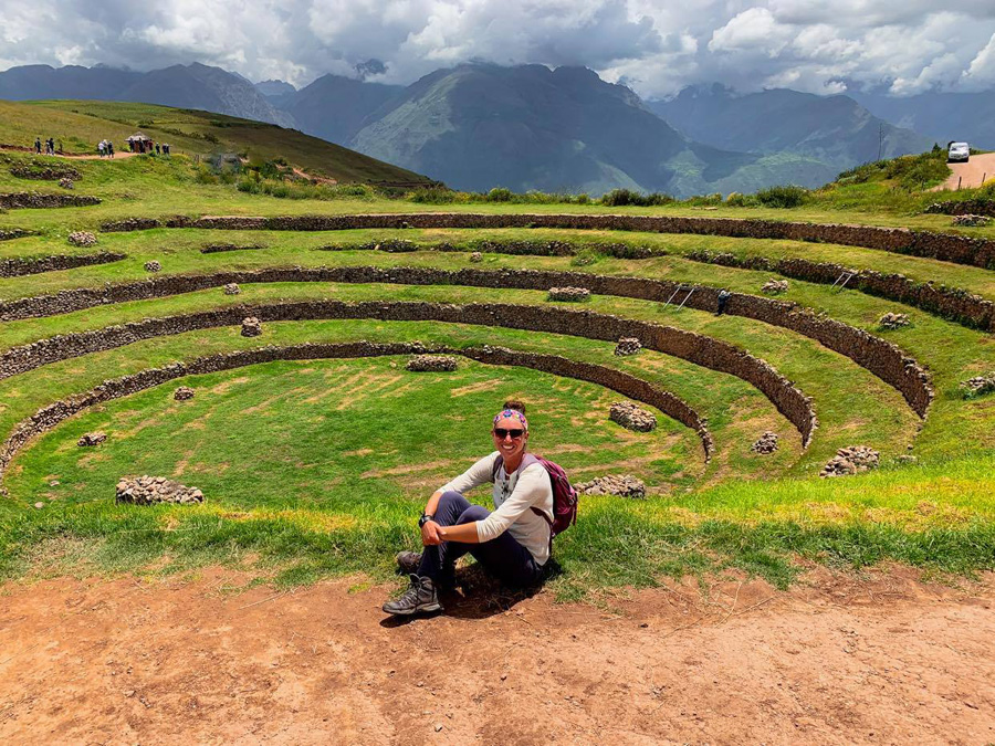 Moray Archaeological Park, Cusco Tourist Ticket Circuit III, woman smiling, Inca terraces, Inca ruins, mountains, clouds, sky, dirt, grass, rocks, stone