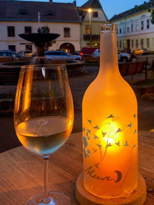 Wine Not?, wine glass, wine bottle, candle, fountain, houses, cars, benches, Sibiu, Romania, best places to drink in Sibiu, wine bars of Sibiu, awesome wine bars in Romania