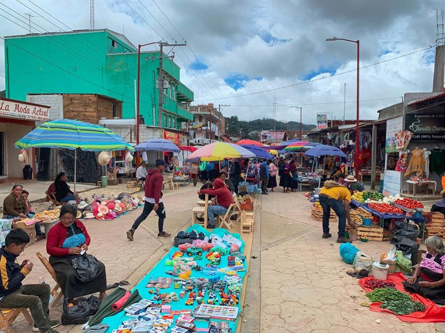 San Juan Chamula Market, street vendors, umbrellas, vegetable stands, people, mountains, clouds, sky, Sunday Market in San Juan Chamula