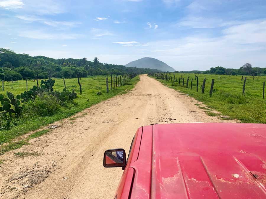 camioneta, how to get to Chacahua, Puerto Escondido to Chacahua, diirt path, cactus, grass, fence, hillside, sky, Chacahua Mexico