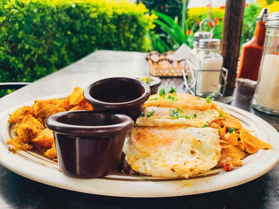 chilaquiles, cafe san sebas, best breakfast in cuenca ecuador, plate, ramekin, plate, table, plaza de san sebastian, plants, condiments