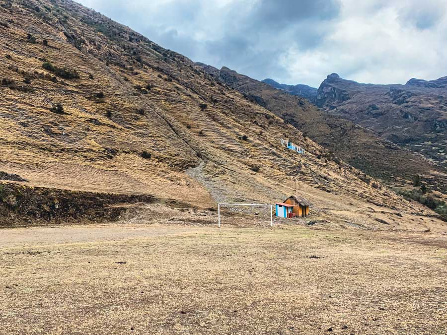 Quuiswarani community, soccer field, grass, mountain, building, lares valley hike