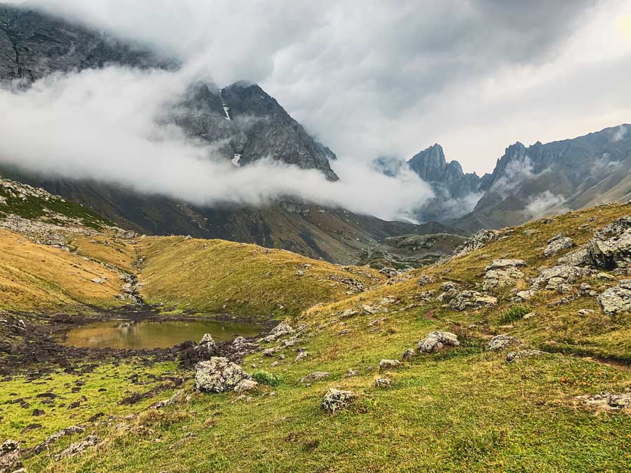 Green Lake, Abudelauri Lakes, Green Abudelauri Lake, Chaukhi Pass, Juta, Roshka, Georgian Dolomites, sky, clouds, snow, hills, mountains, lake, hiking trail, rocks, grass, Georgia