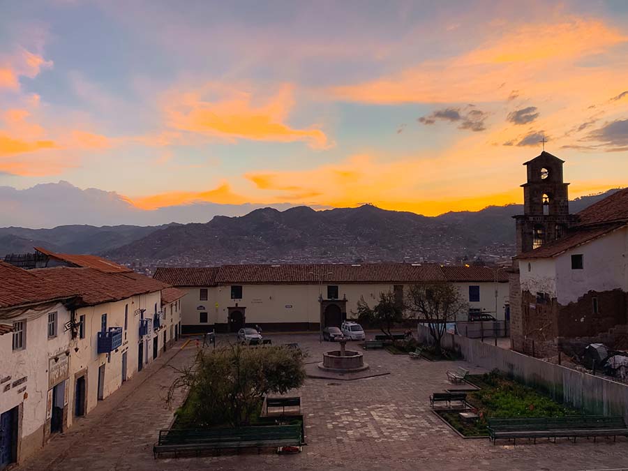 Sunset over San Blas Plaza in Cusco provide sweeping views of the Andes Mountains, the San Blas Church, and impressive colonial buildings