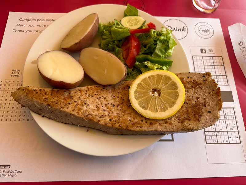 fish fillet with lemon, salad, and potatoes at restaurant Faialense São Miguel