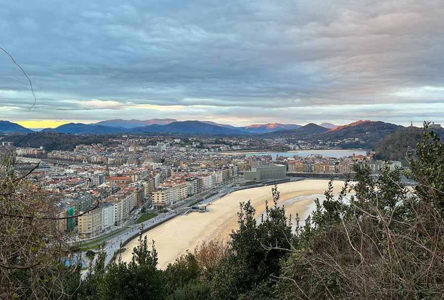 a city view of Donostia-San Sebastian with Zurriola Beach and mountains in the far distance