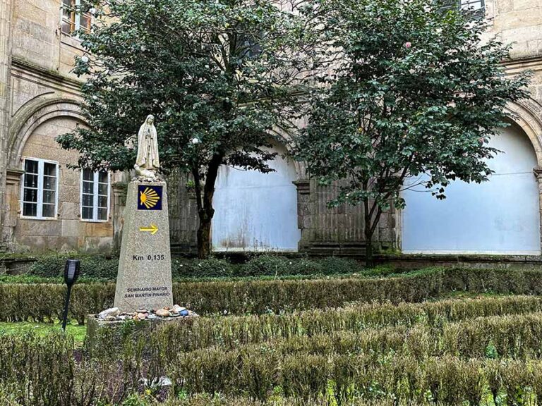 Hospedaría San Martiño Pinario courtyard has a Camino KM marker for the cathedral